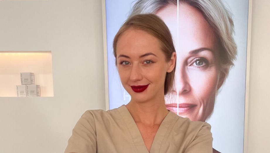 Professional at Skin Aesthetic in Trowbridge, England, GB, standing confidently in front of a beauty poster.
