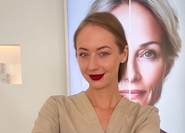 Professional at Skin Aesthetic in Trowbridge, England, GB, standing confidently in front of a beauty poster.