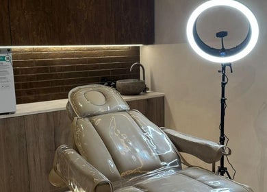 Modern treatment room at Lomas Laser & Beauty (MOSTON), Manchester, England, GB, featuring a sleek chair and lighting.