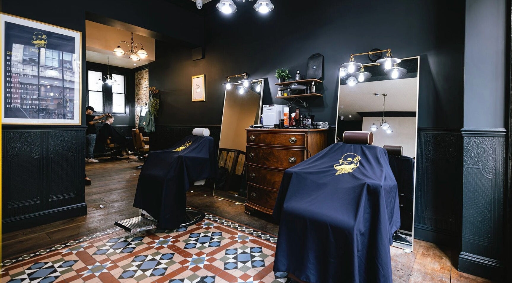 Cozy interior of Tom's Barbers in London, England, GB, featuring classic barber chairs and décor.