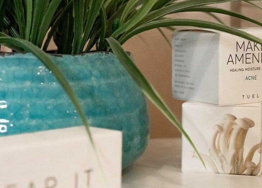 White skincare products beside a vibrant blue plant pot at Sugar Maui, Kihei, Hawaii, US.