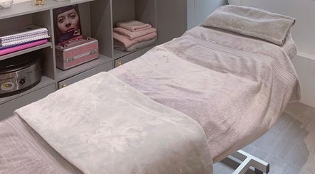 Cozy treatment bed in Nailsquad, Deal, England, GB with soft pink towels and elegant storage.