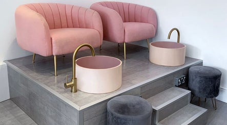 Luxurious pedicure chairs at Nailsquad, Deal, England, GB, with plush pink seating and elegant washbasins.
