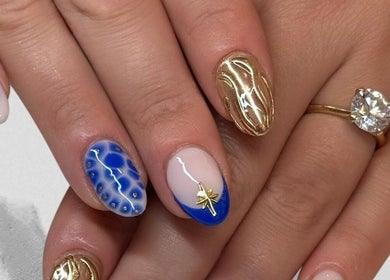 Elegant blue and gold nail art at Nailsquad, Deal, England, GB showcasing intricate details.
