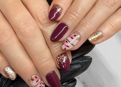 Exquisite burgundy and gold nails at Nailsquad, Deal, England, GB. Perfect blend of elegance and style.