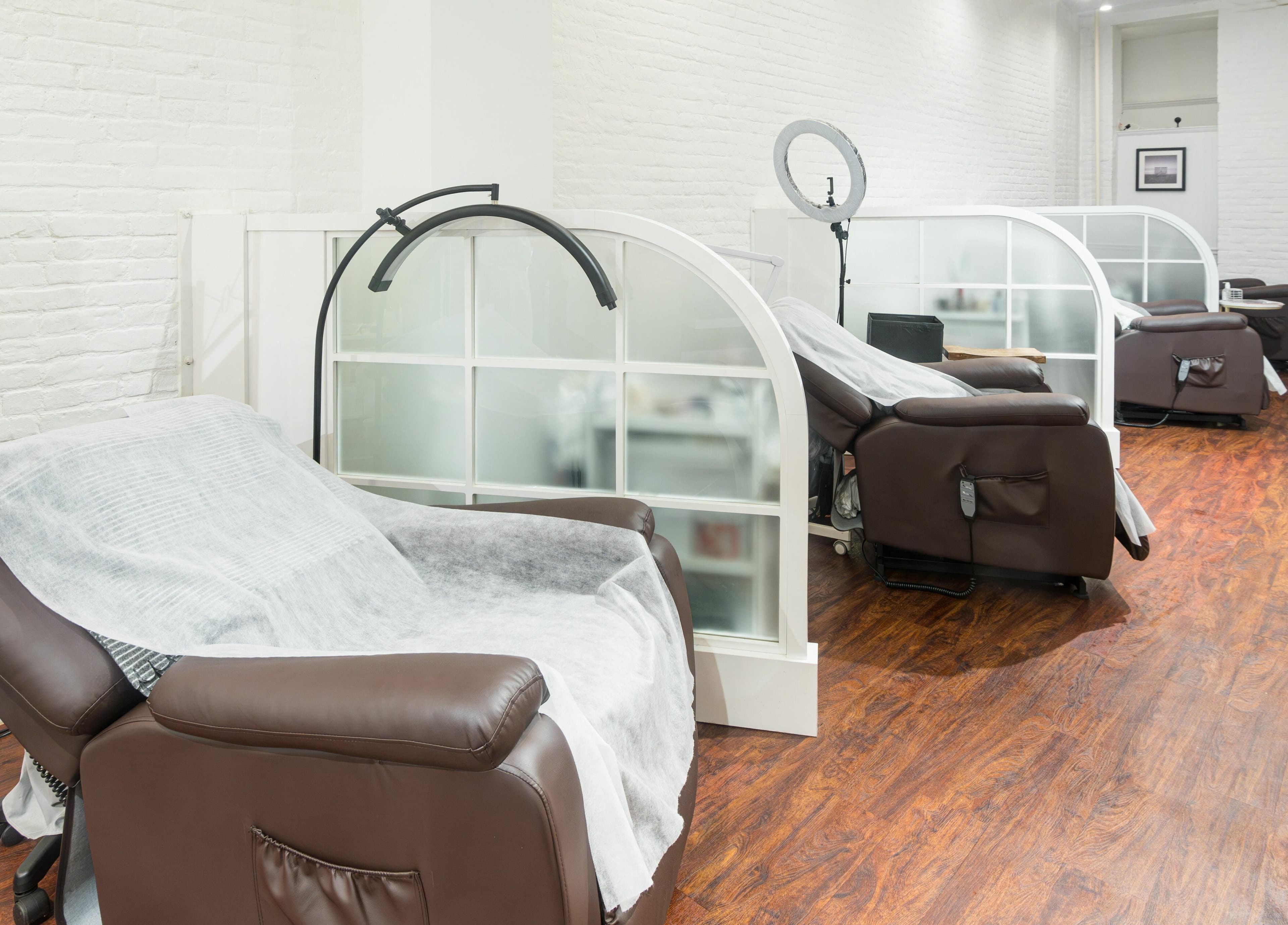 Relaxing lounge area at Lash-bar Foula in New York, New York, US with cozy chairs and modern decor.