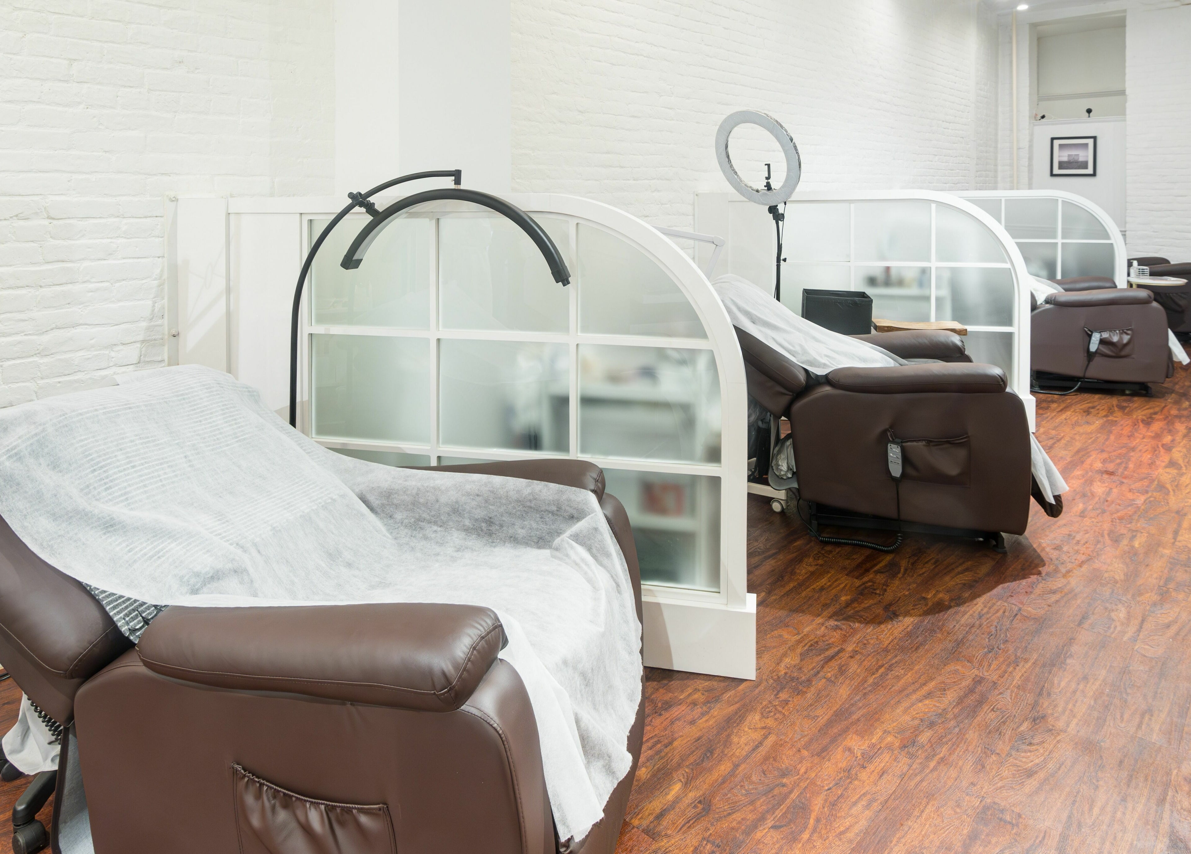 Relaxing lounge area at Lash-bar Foula in New York, New York, US with cozy chairs and modern decor.