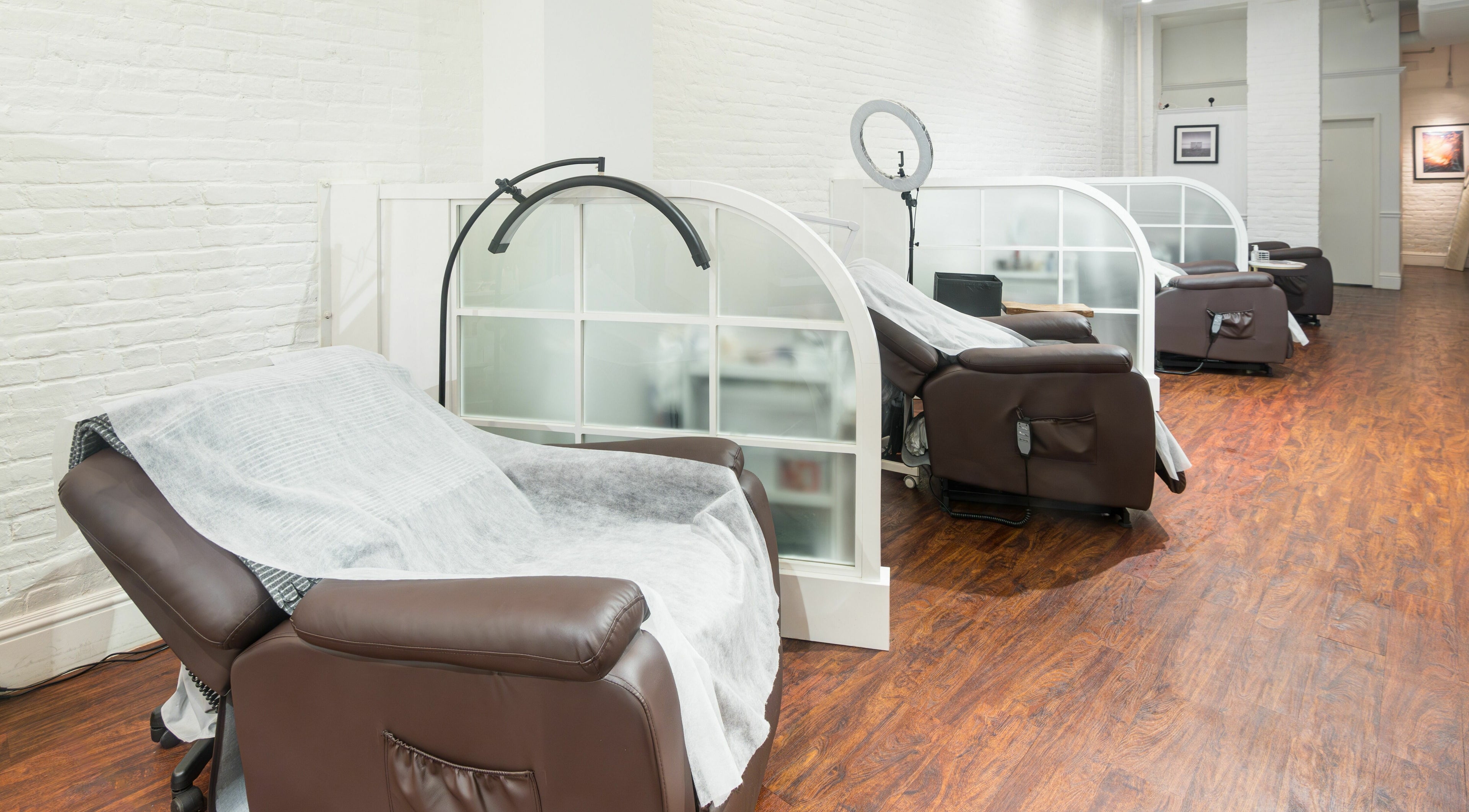 Relaxing lounge area at Lash-bar Foula in New York, New York, US with cozy chairs and modern decor.