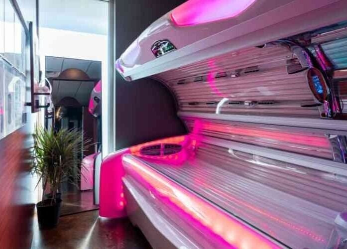 Bright tanning bed at After Glow Tanning & Beauty - North Providence, Rhode Island, US with pink lights.