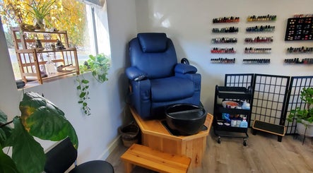 Elegant pedicure chair at Royal Digits, Etna, California, US, surrounded by nail polish selection and plants.