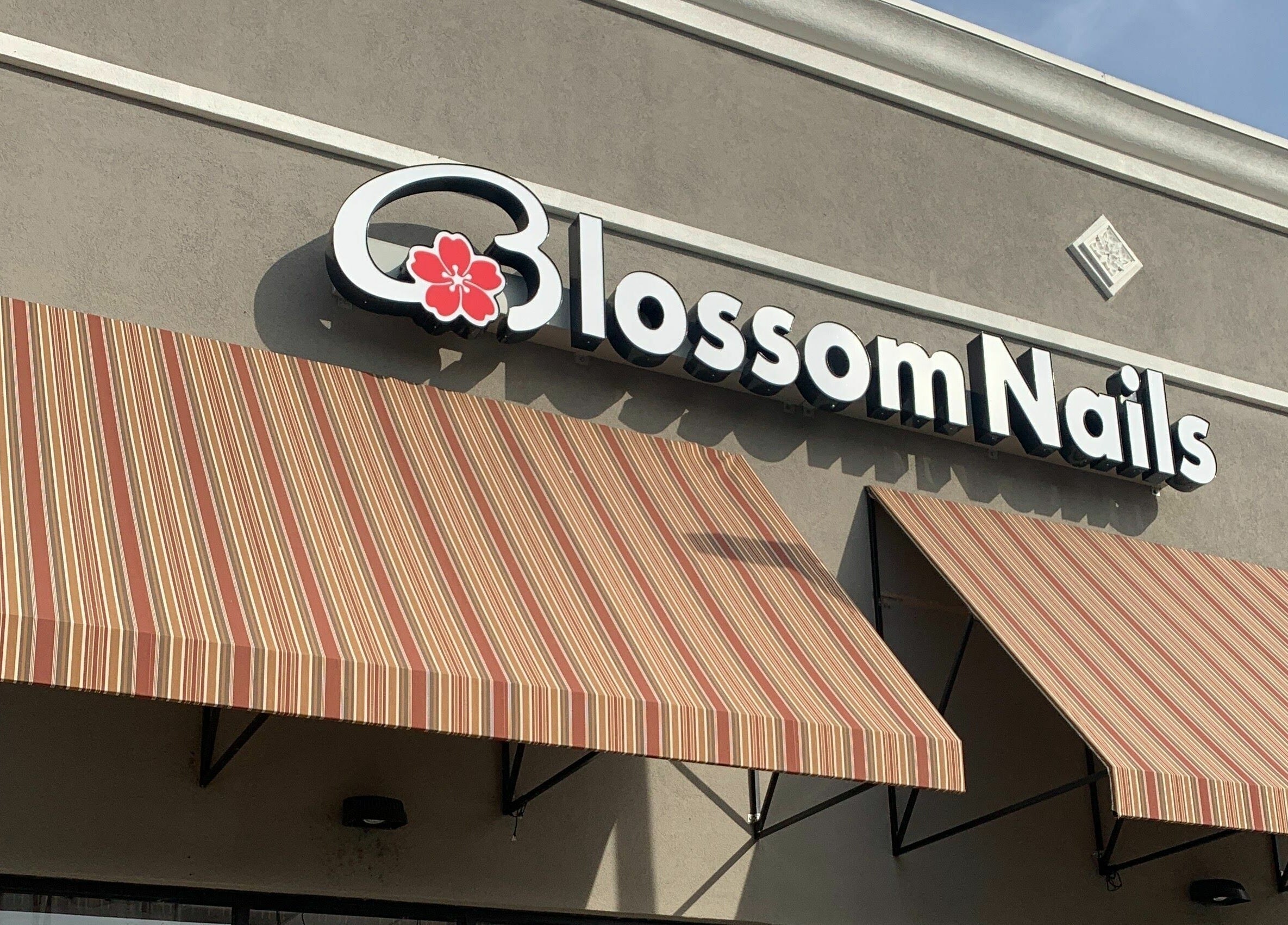 Blossom Nails storefront with striped awnings in Sanford, Florida, US.