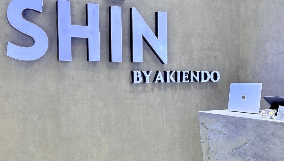 Front desk at SHIN by AKIENDO (Ari branch), Krung Thep Maha Nakhon, with a modern sign and sleek counter.