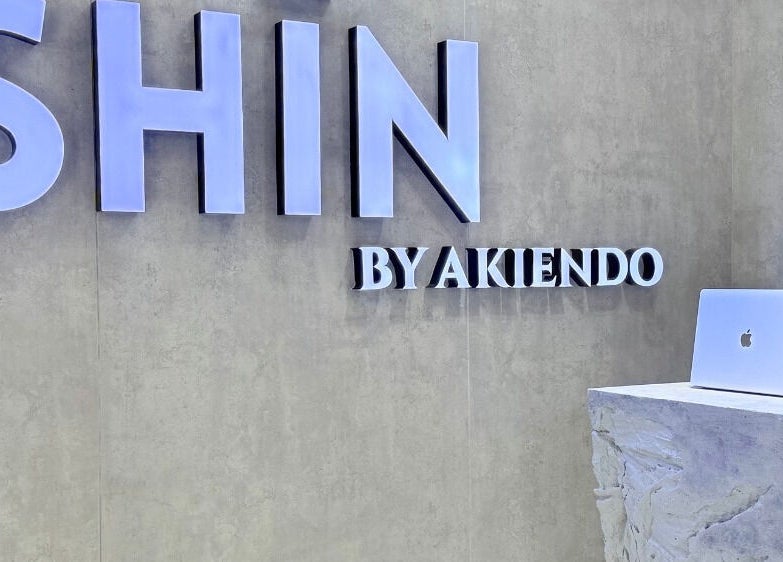 Front desk at SHIN by AKIENDO (Ari branch), Krung Thep Maha Nakhon, with a modern sign and sleek counter.