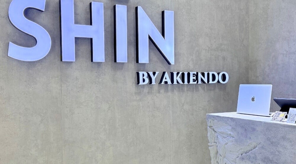 Front desk at SHIN by AKIENDO (Ari branch), Krung Thep Maha Nakhon, with a modern sign and sleek counter.