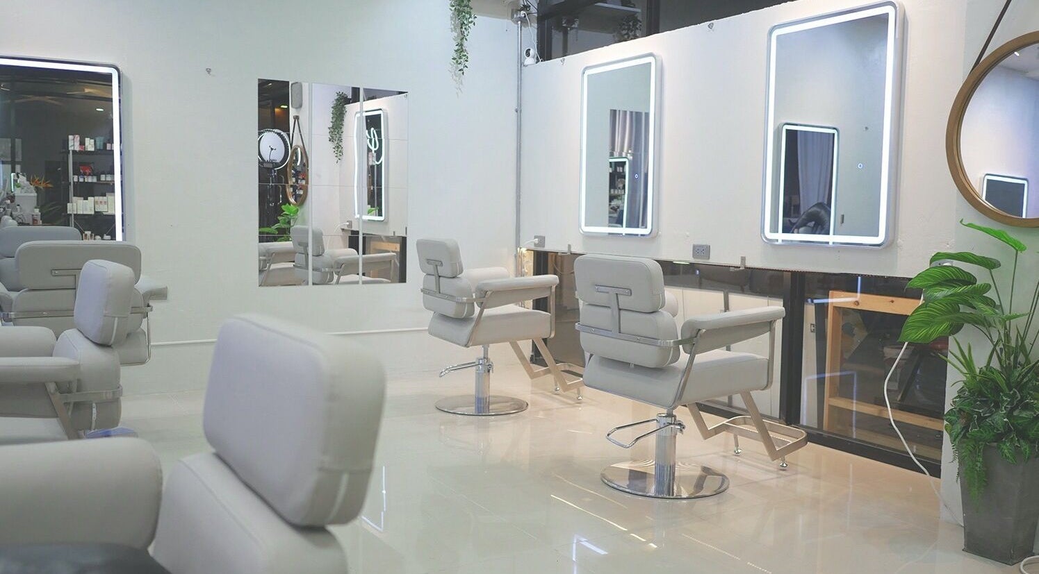 Modern interior of AKIENDO Hair Salon (Phrom phong Main Branch) in Bangkok, featuring stylish chairs and mirrors.