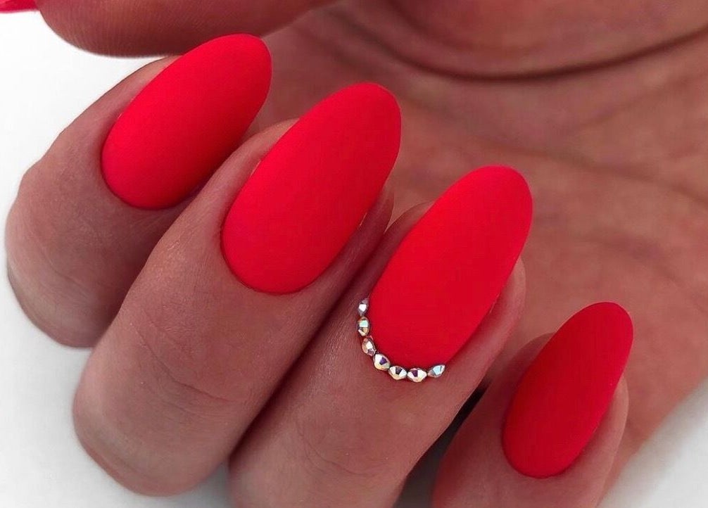 Stunning red manicure with gem accents at Nail Art Studio, Gainsborough, England, GB.