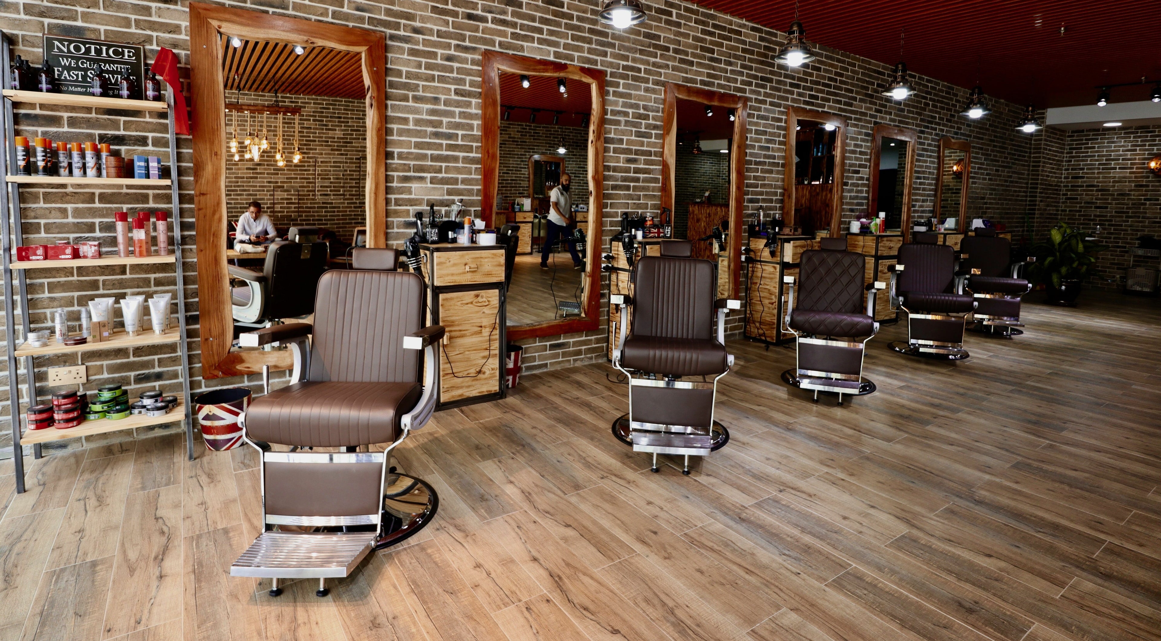 Interior of Peaky Blinders barbershop in Dubai, AE featuring stylish chairs and wooden mirror frames.