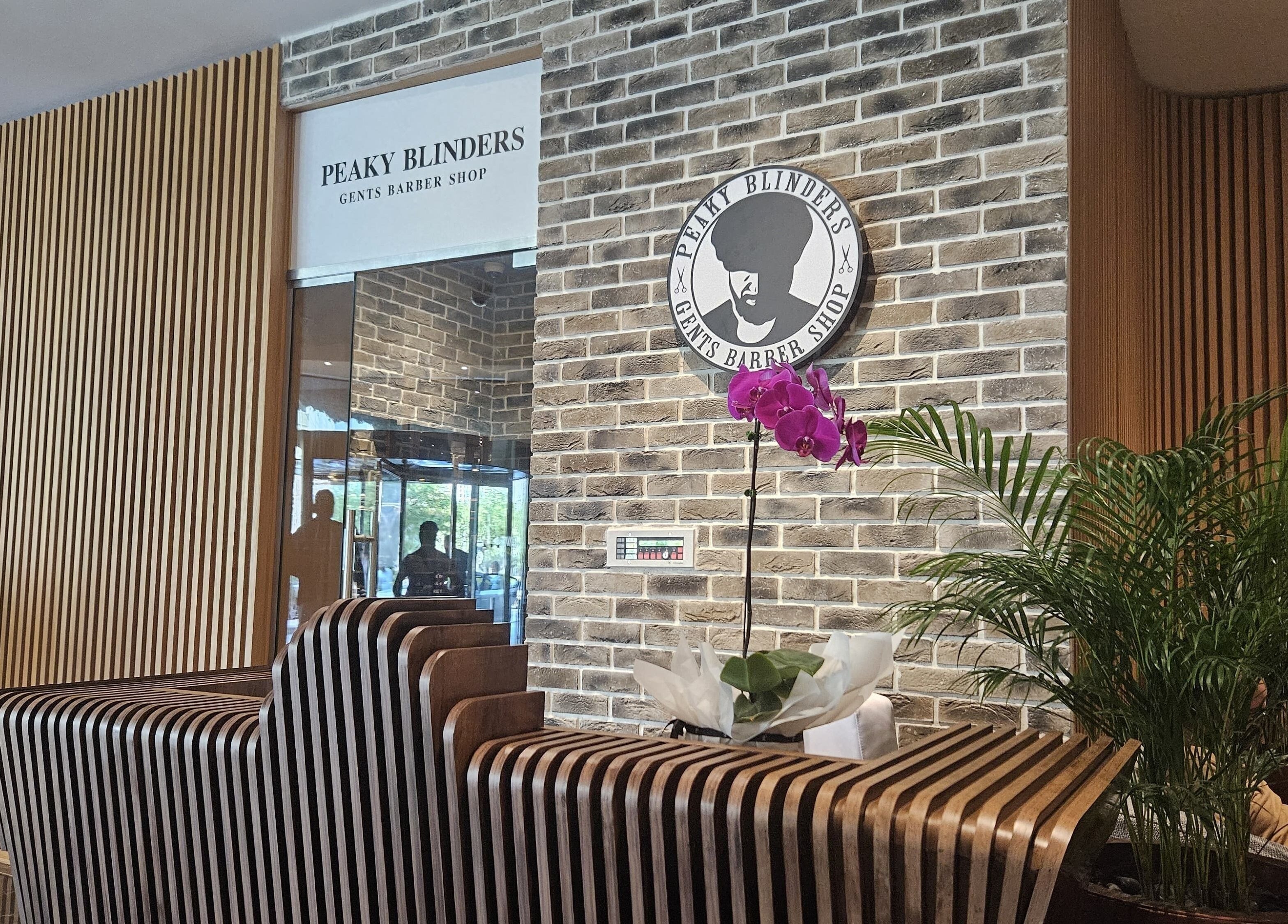 Sleek entrance of Peaky Blinders | Five JVC, Dubai, Dubai, AE, featuring modern decor and vibrant plants.