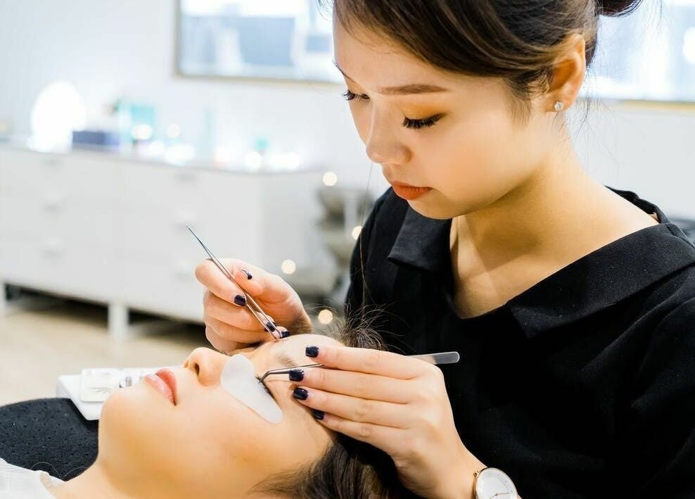 Lash technician at Divine Brow Lash & Skincare - Surry Hills applying extensions, Surry Hills, New South Wales.