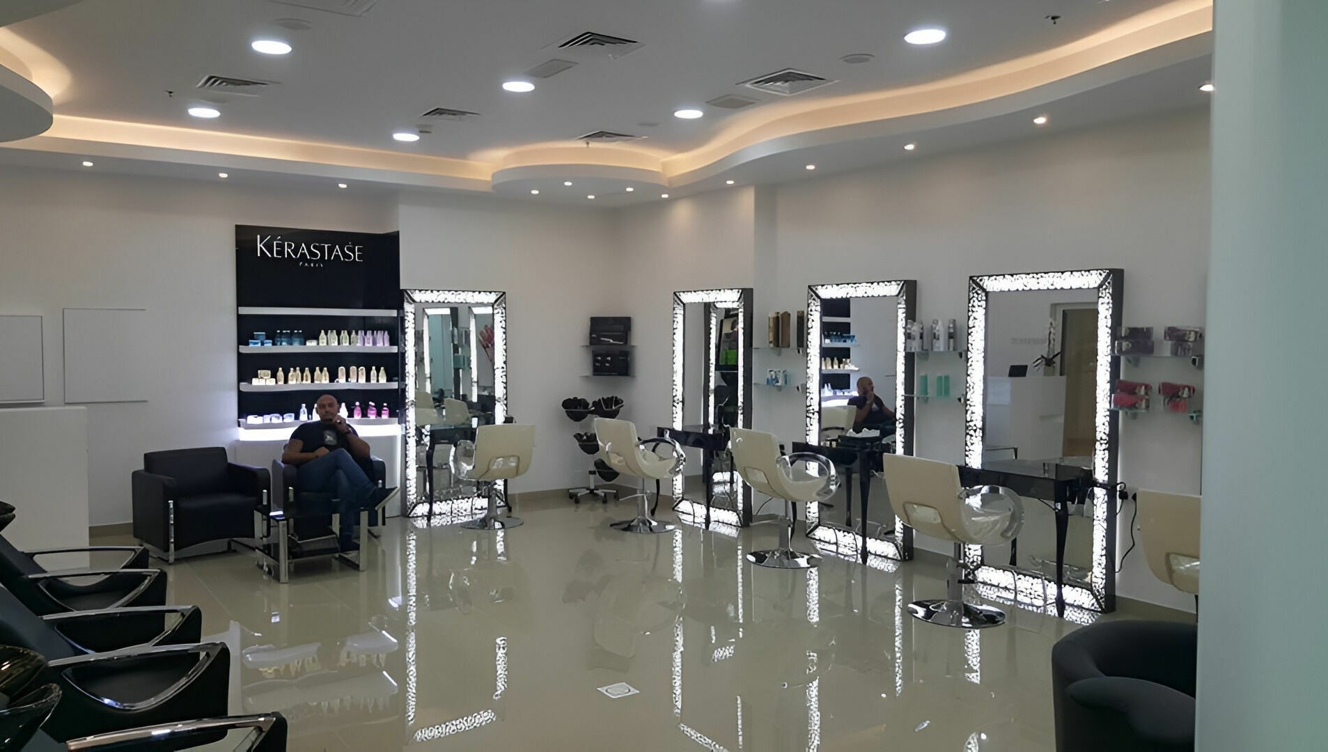 Interior of Robert Alexander Salon in Dubai, Dubai, AE, showcasing stylish chairs and illuminated mirrors.