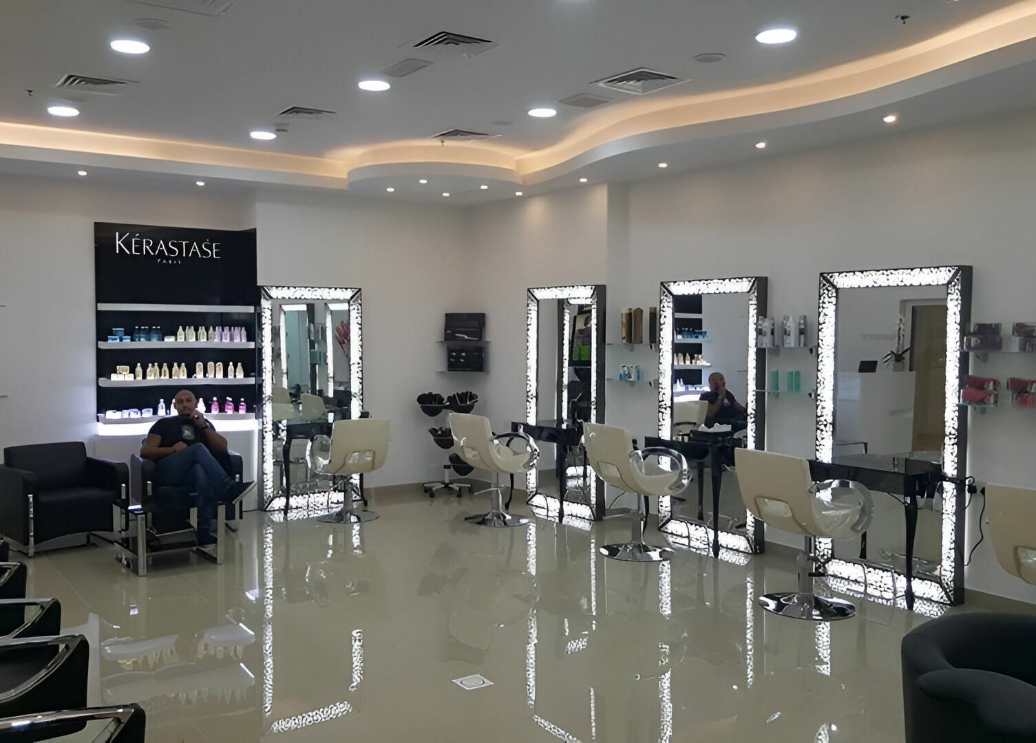 Interior of Robert Alexander Salon in Dubai, Dubai, AE, showcasing stylish chairs and illuminated mirrors.