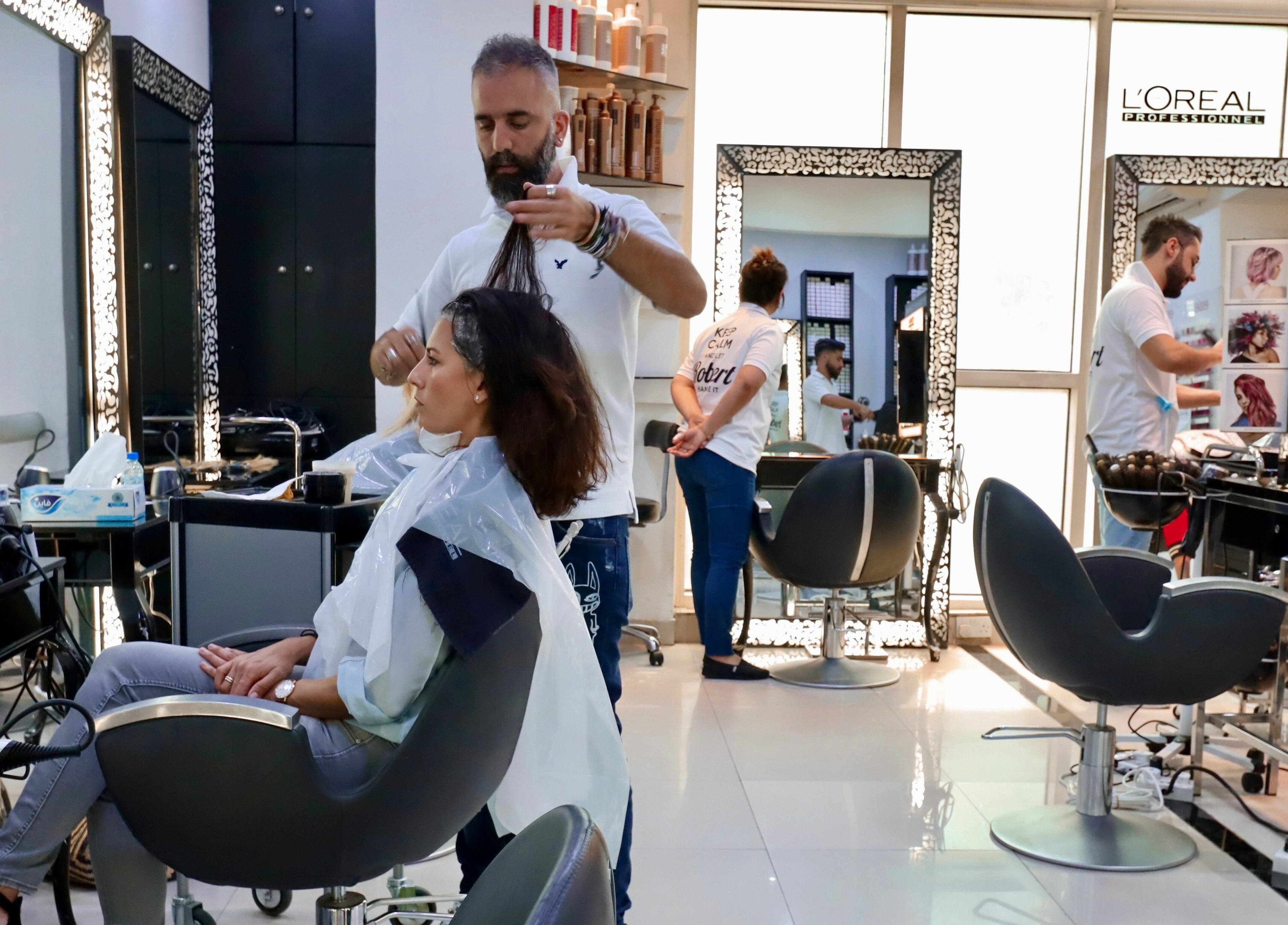 Hair stylist perfecting a client's look at Robert Alexander Salon, Dubai, Dubai, AE.