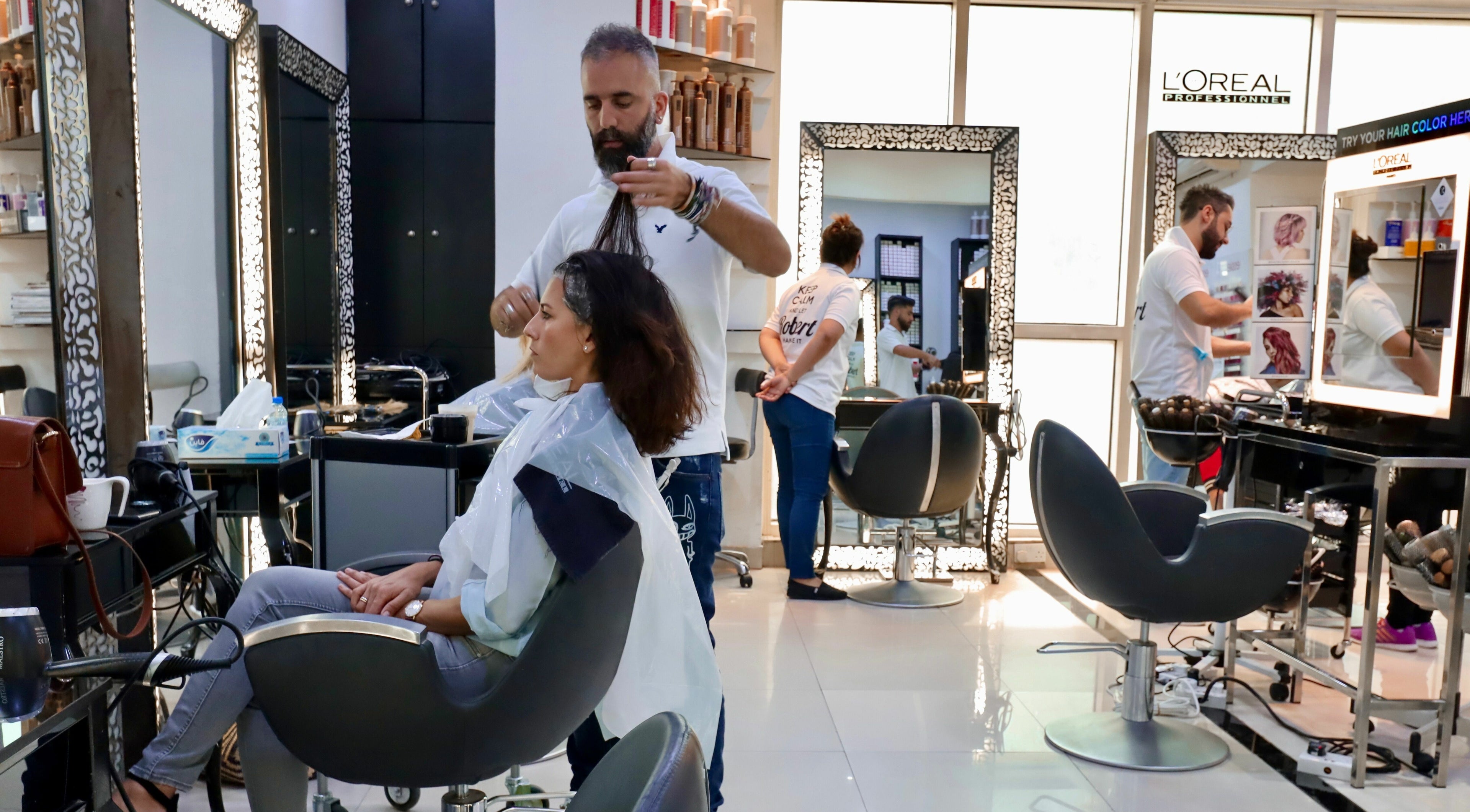 Hair stylist perfecting a client's look at Robert Alexander Salon, Dubai, Dubai, AE.