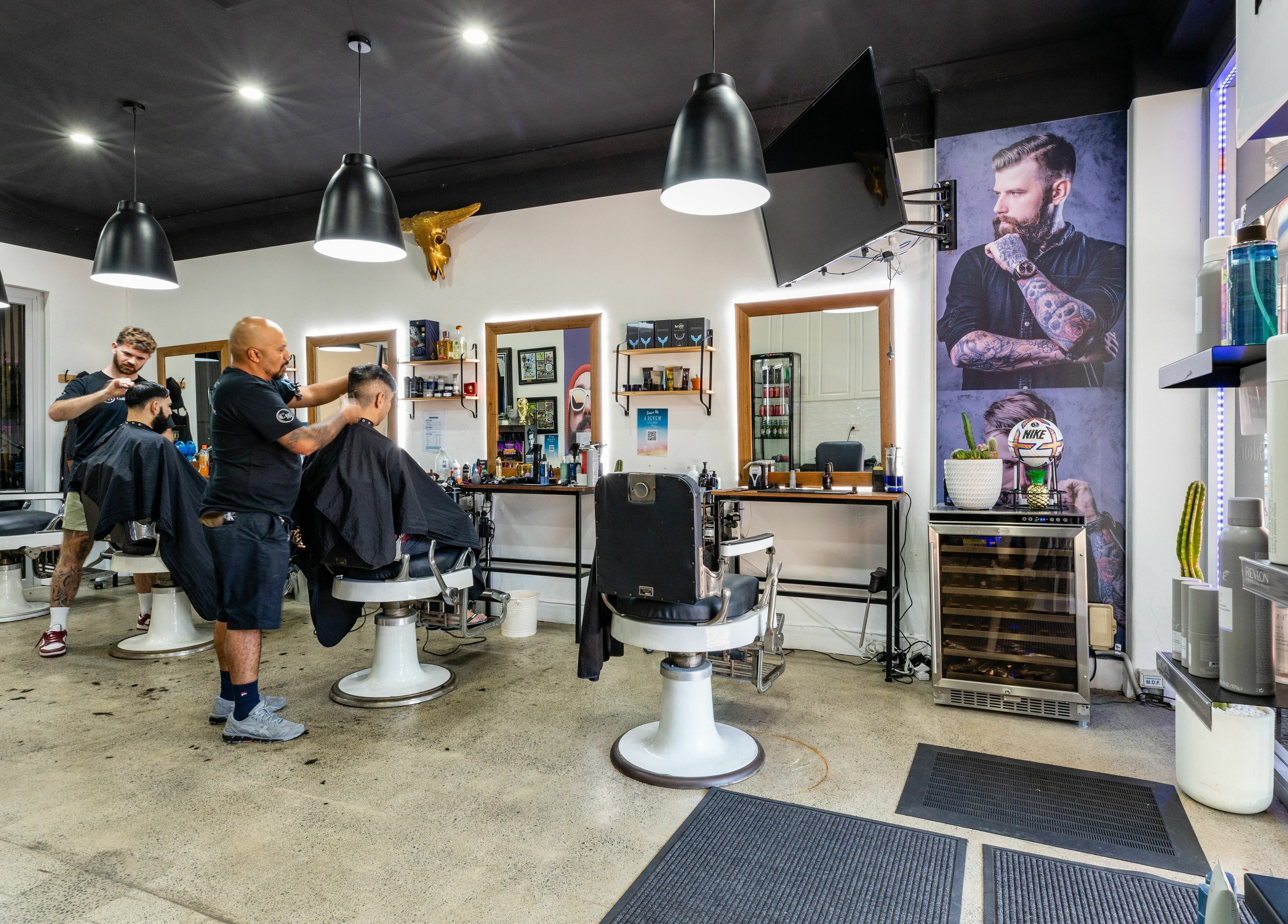 Stylish interior of Collective Hair at Mascot, Pensioners 25% Off, AU showcasing skilled barbers at work.