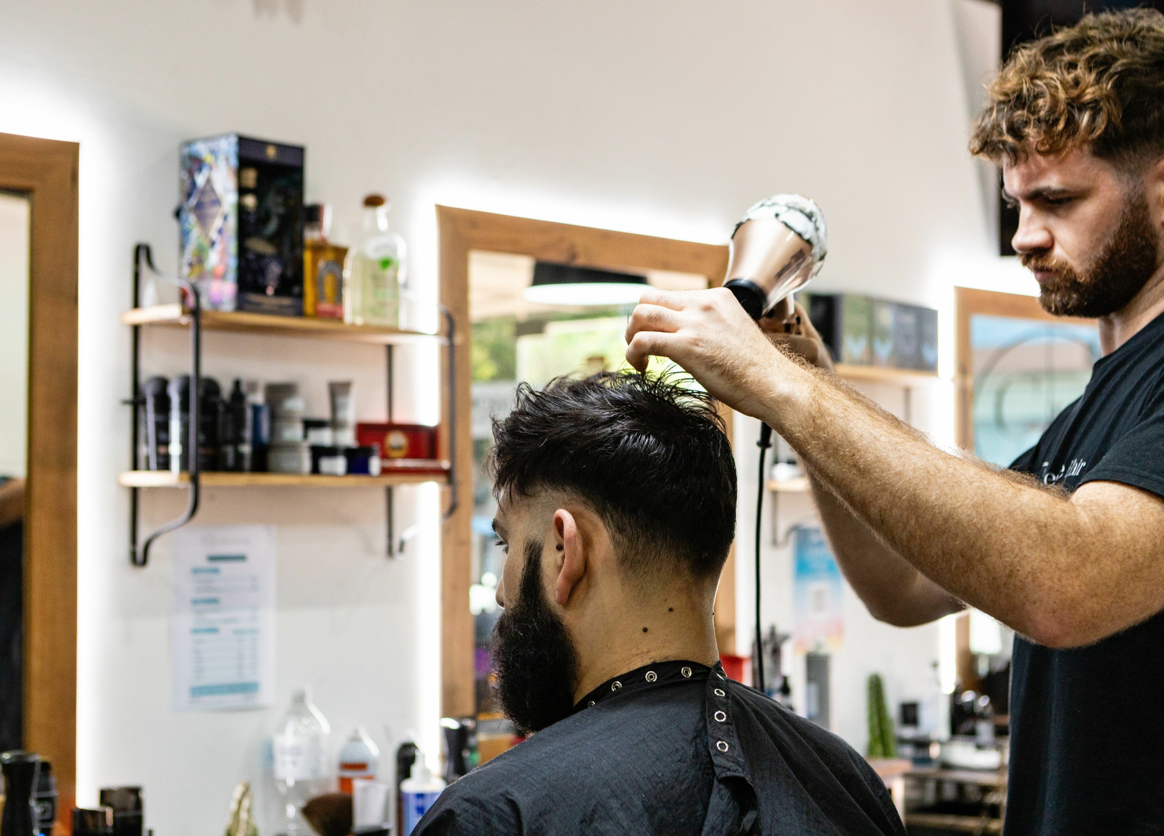 Stylist expertly cutting hair at Collective Hair, Mascot, Pensioners 25% Off, AU. Modern salon vibe.