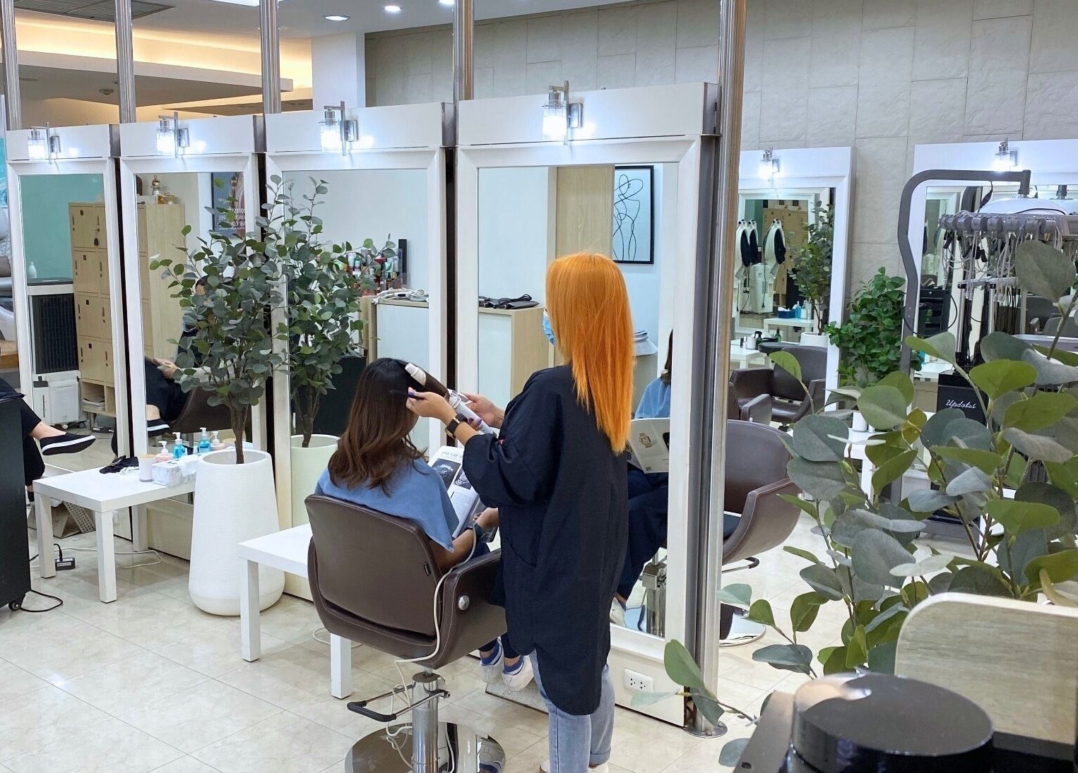 Hair stylist working at Niche Salon Bangkok, Krung Thep Maha Nakhon, TH. Modern beauty and wellness ambiance.