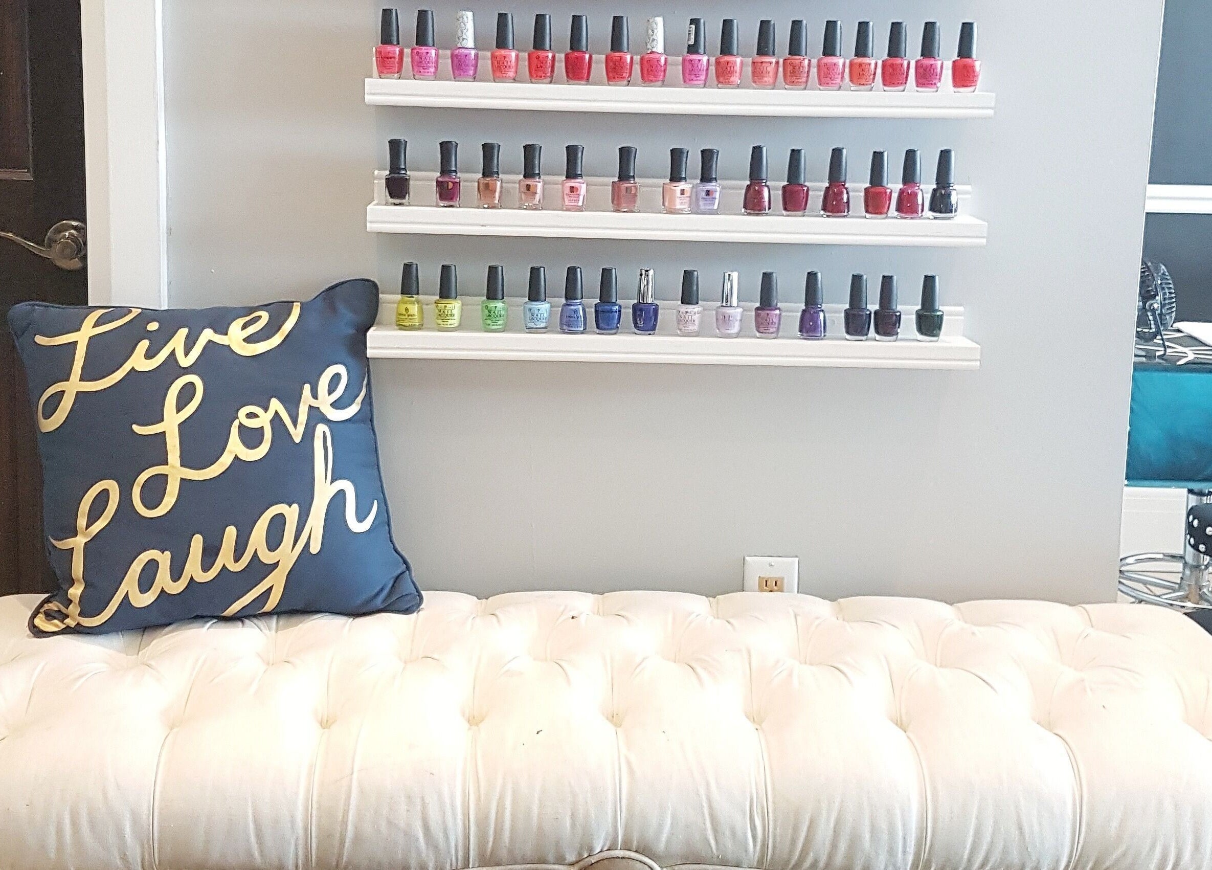Elegant nail polish display at Dazzle Nailspa, Toronto, Ontario, CA with plush seating and motivational decor.