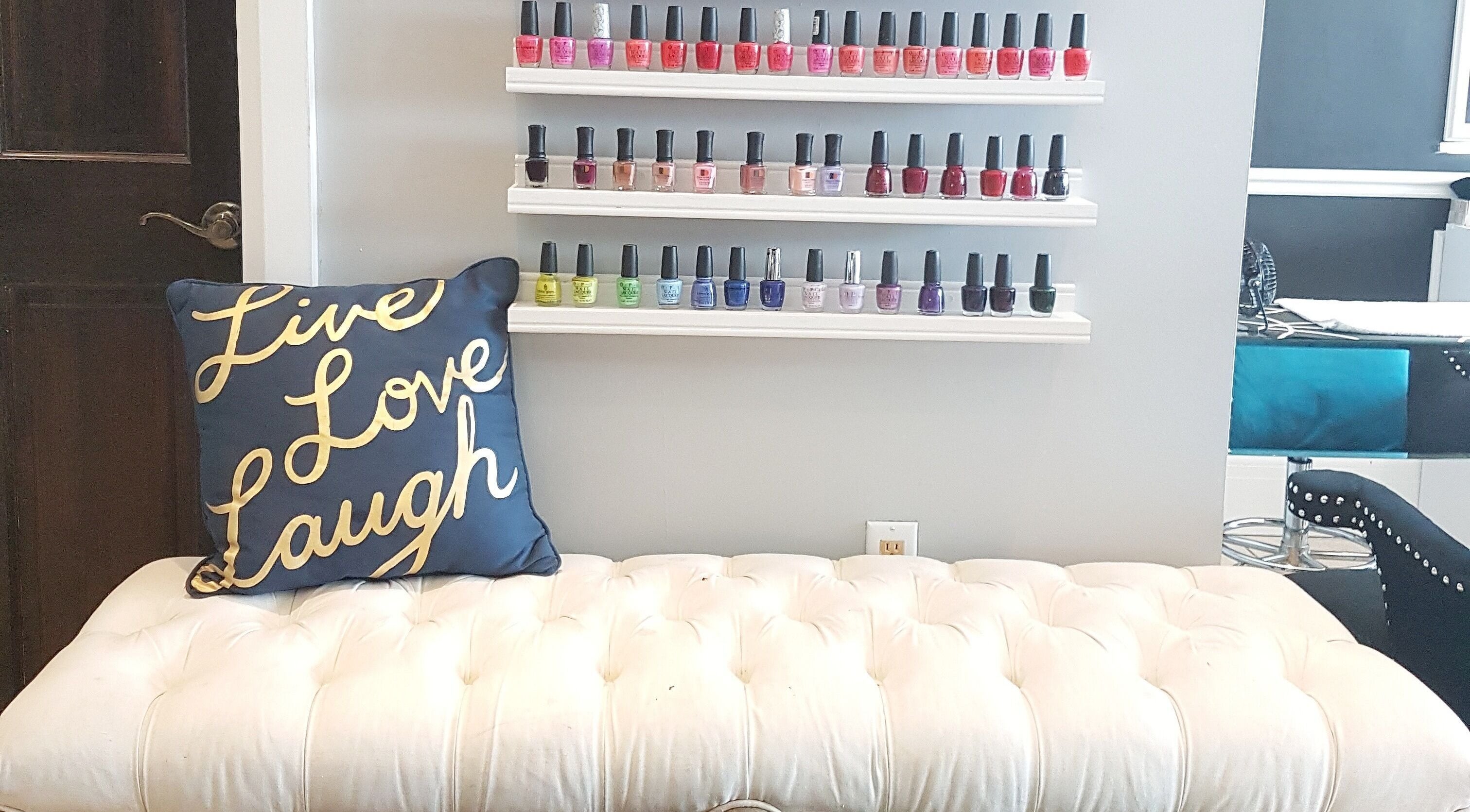 Elegant nail polish display at Dazzle Nailspa, Toronto, Ontario, CA with plush seating and motivational decor.