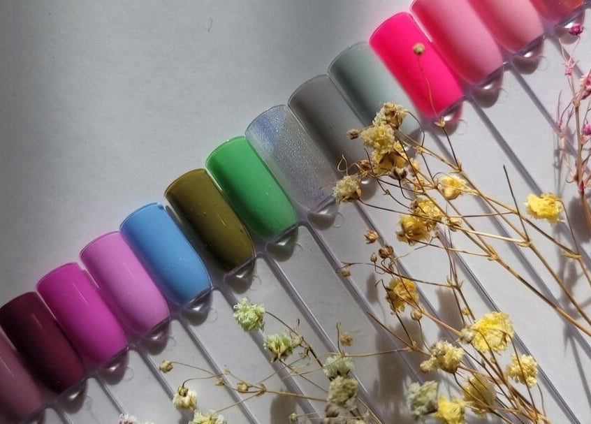 Vibrant nail polish samples at Dazzle Nailspa, Toronto, Ontario, CA, showcasing diverse colors with florals.