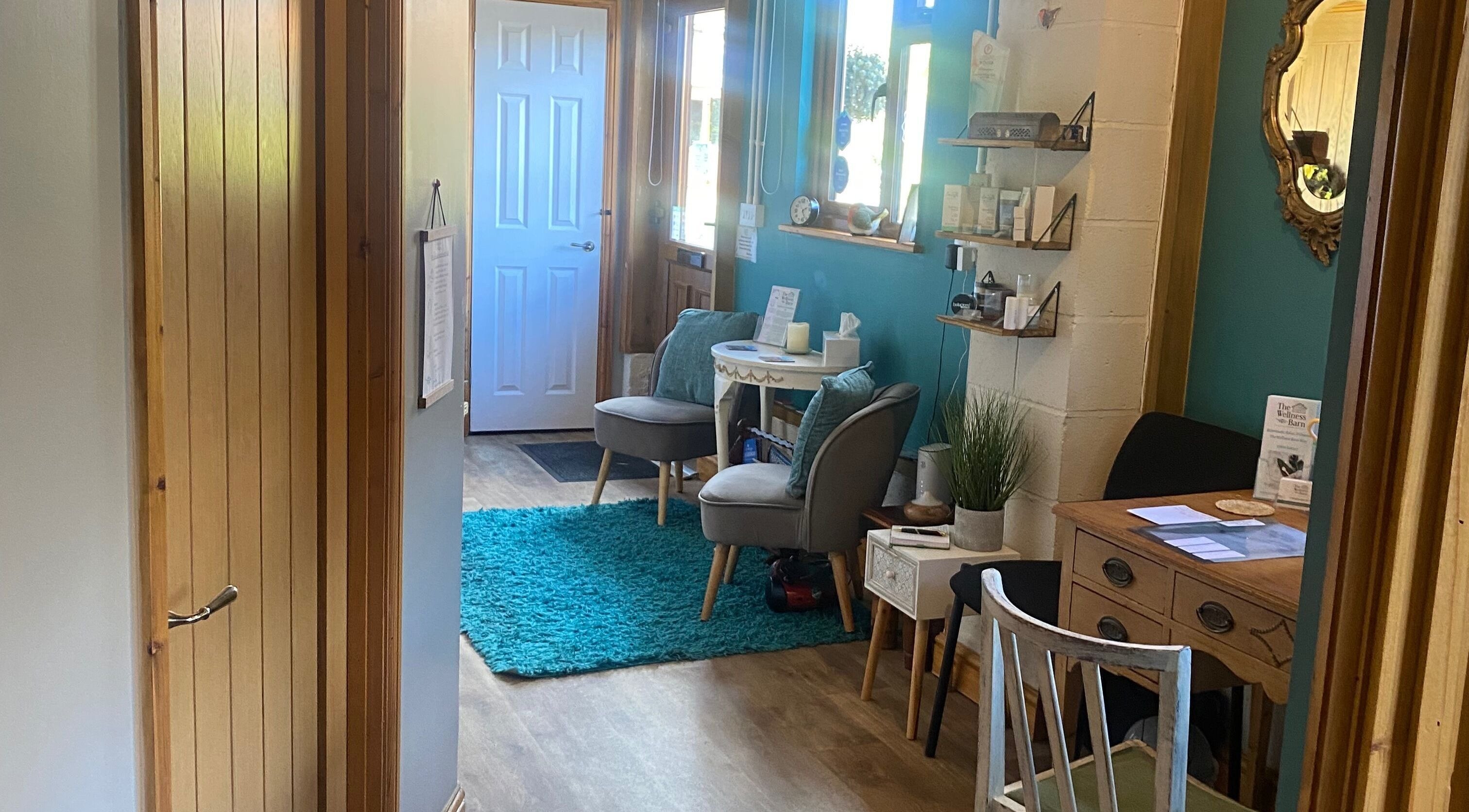 Cozy reception area at The Wellness Barn, Gatcombe, England, GB with teal decor and comfortable seating.