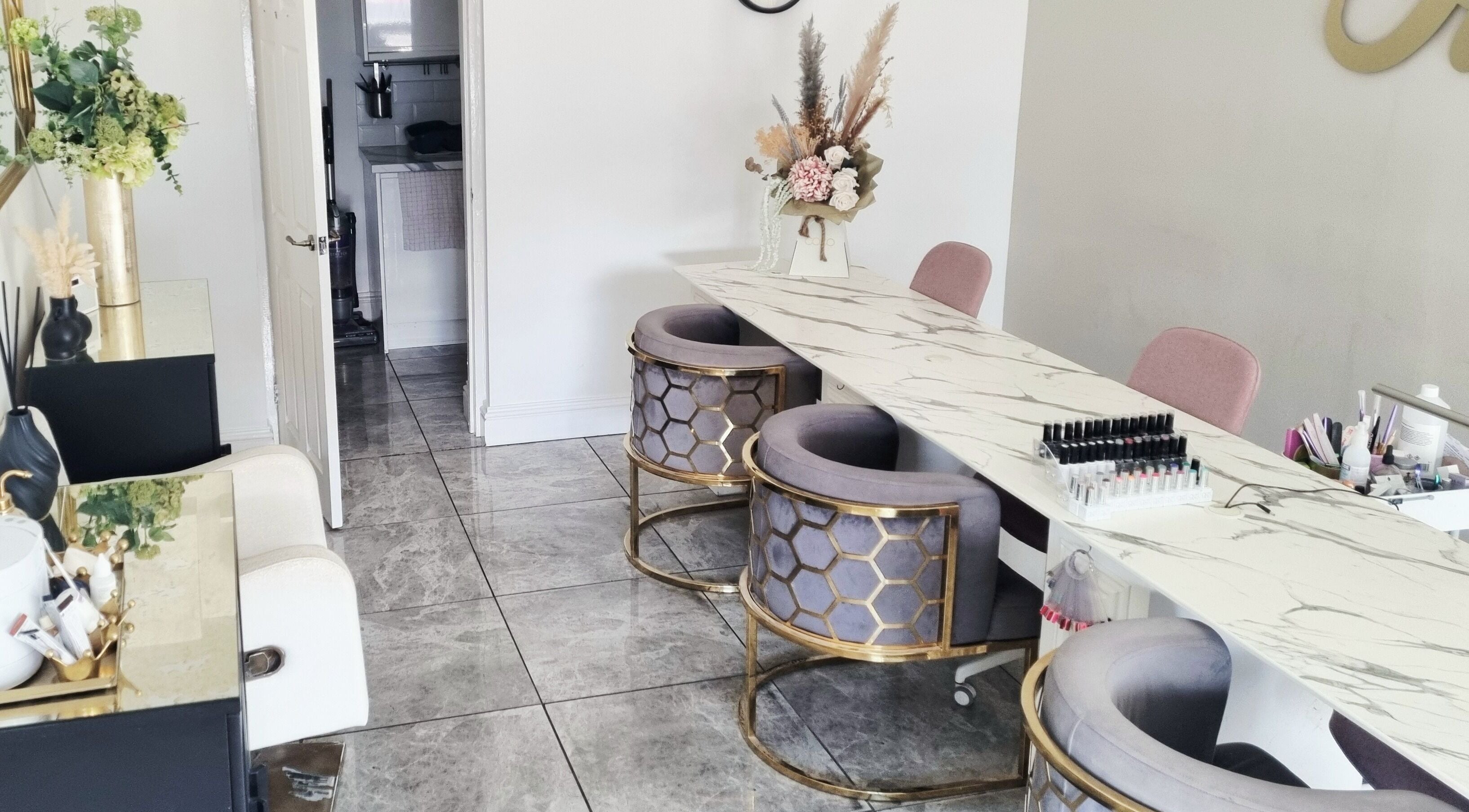 Chic nail table setup at Hiive Expert Nails in Swinton, England, GB, featuring plush seating and marble decor.