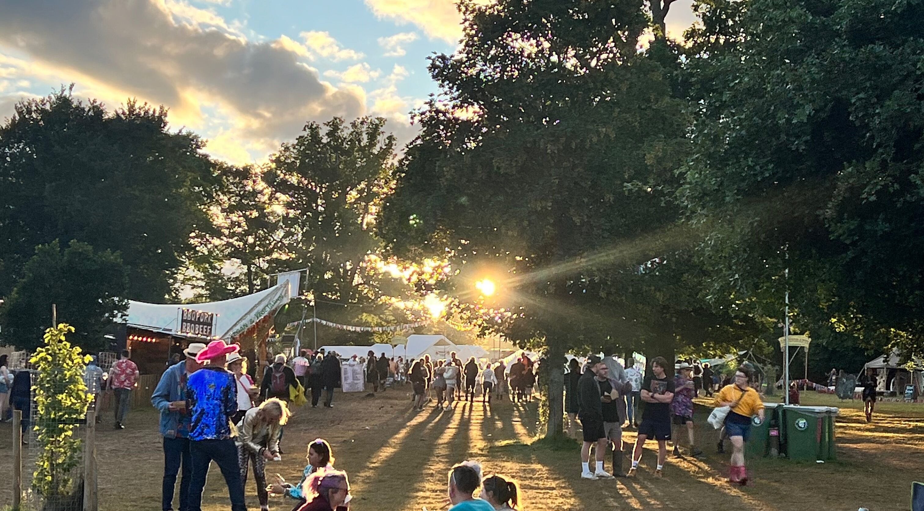 A vibrant outdoor event at Latitude Luxury, Southwold, England, GB with people enjoying the sunset.
