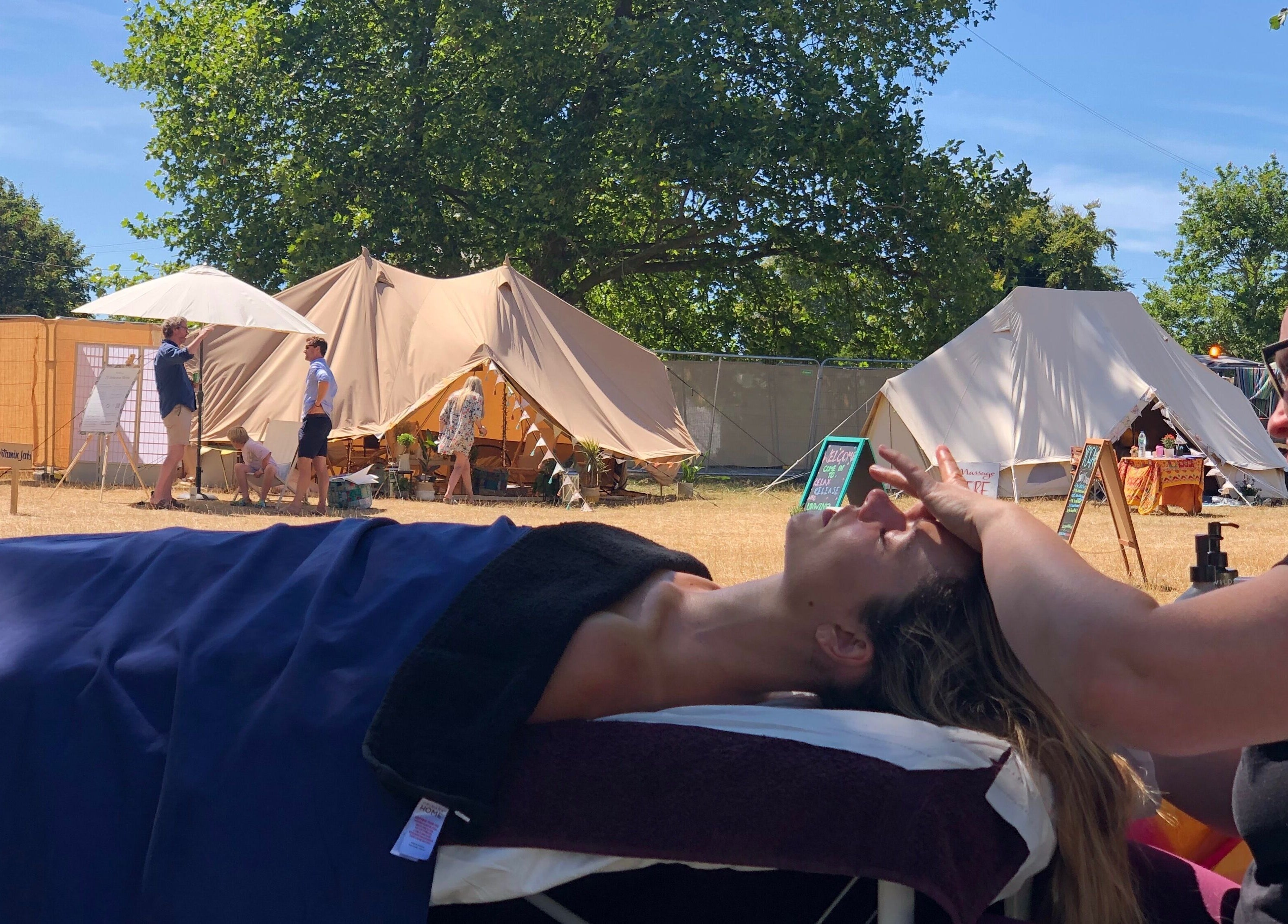 Relaxing facial massage at Latitude Luxury, Southwold, England, GB amidst outdoor tents.