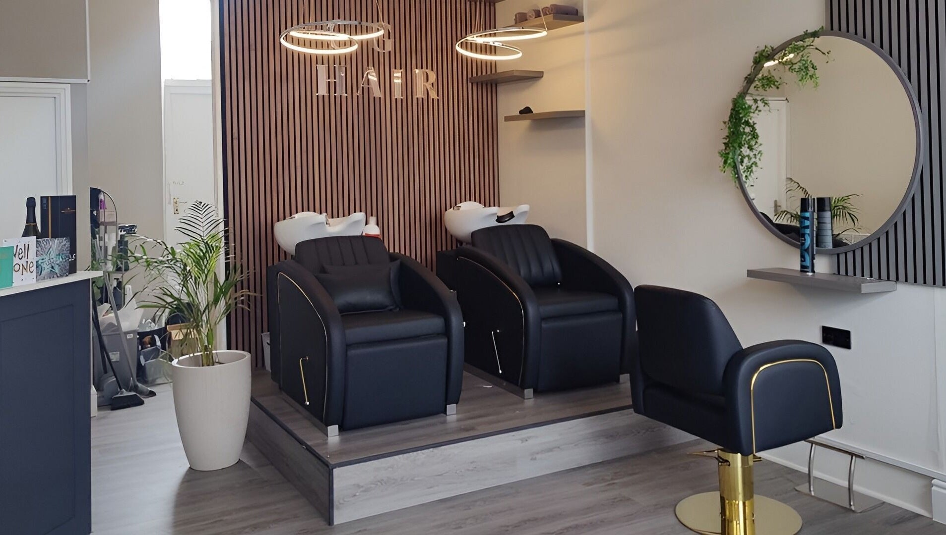 Modern salon interior at Chelsea Geddes Hair in Peel, Peel, IM, featuring sleek black chairs and stylish decor.