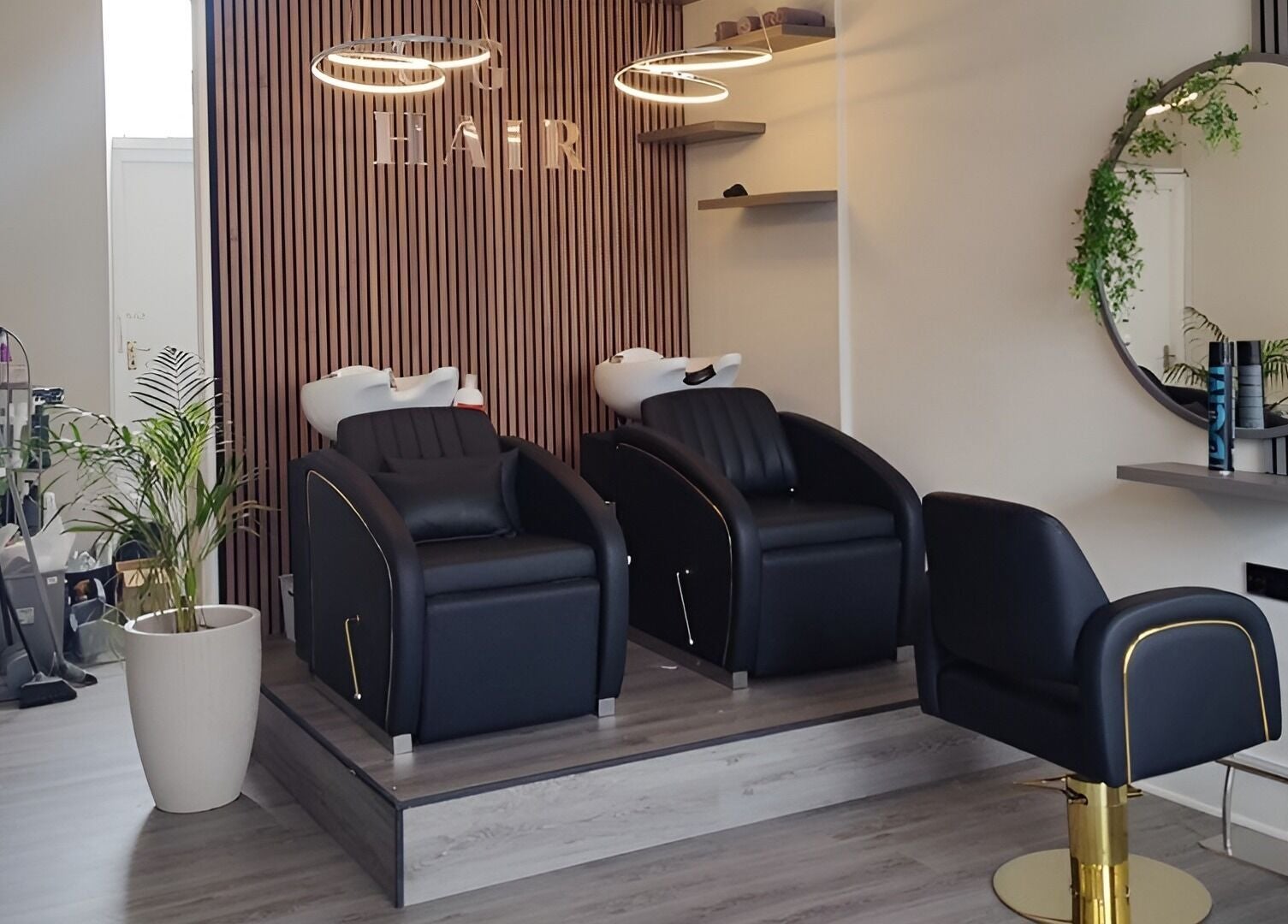 Modern salon interior at Chelsea Geddes Hair in Peel, Peel, IM, featuring sleek black chairs and stylish decor.