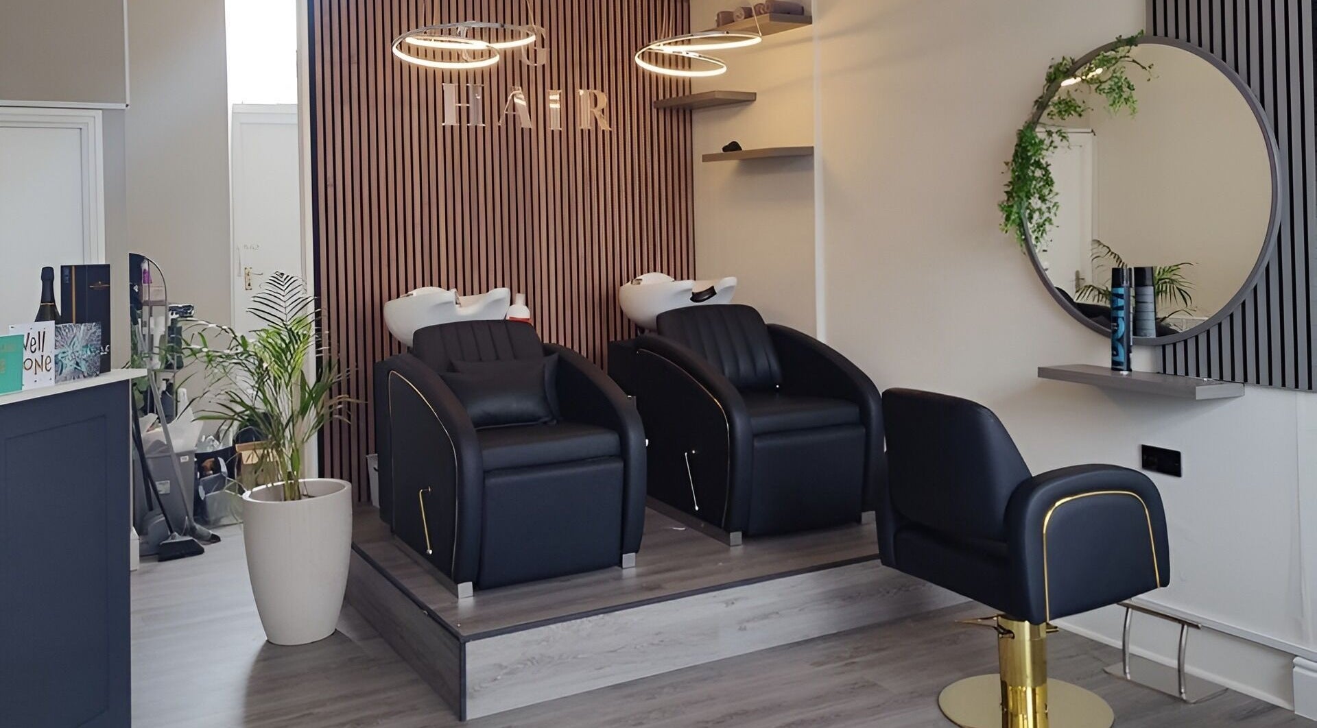 Modern salon interior at Chelsea Geddes Hair in Peel, Peel, IM, featuring sleek black chairs and stylish decor.