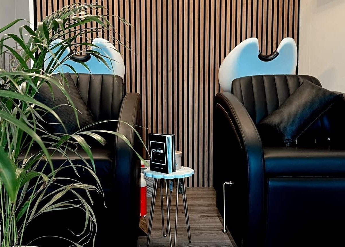 Modern wash stations at Chelsea Geddes Hair, Peel, Peel, IM, featuring sleek black chairs.