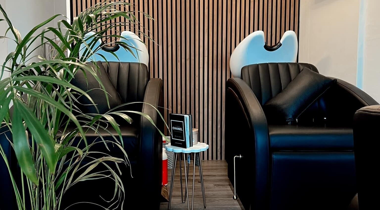 Modern wash stations at Chelsea Geddes Hair, Peel, Peel, IM, featuring sleek black chairs.