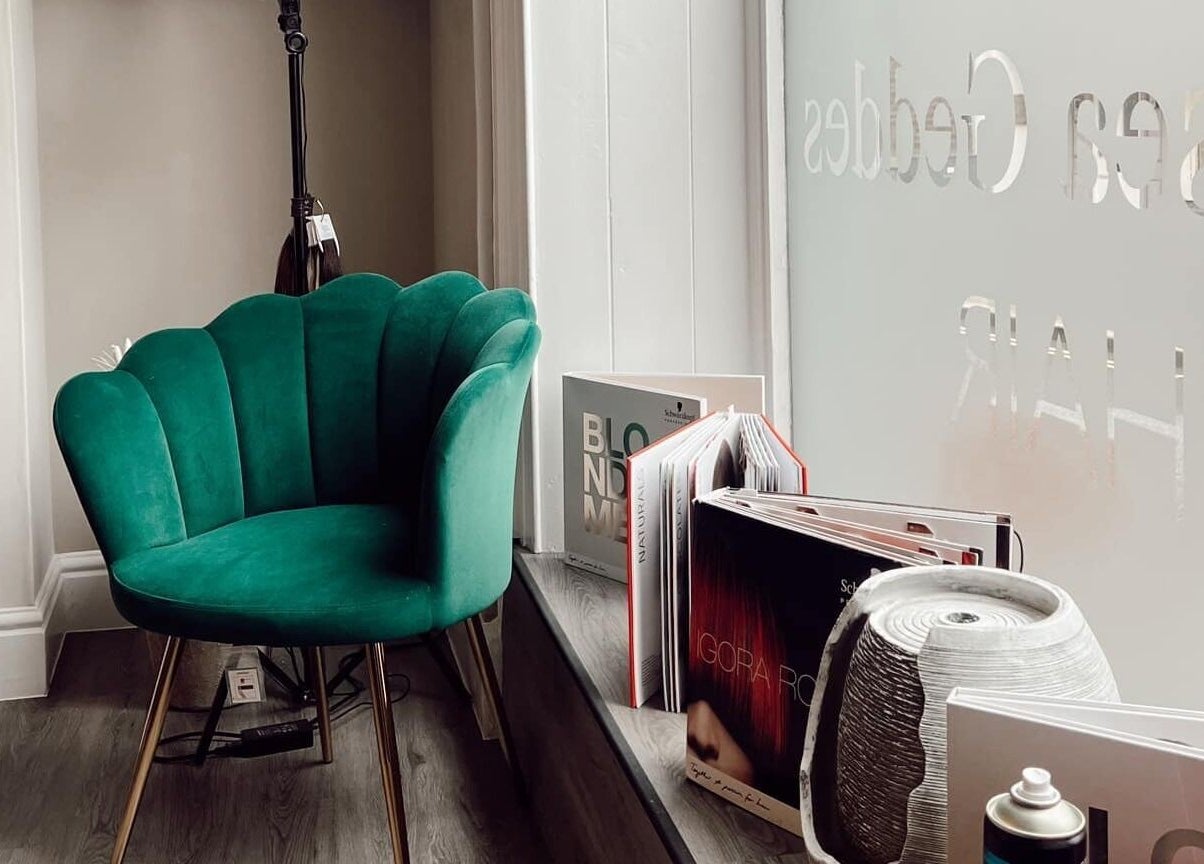 Emerald chair by the window at Chelsea Geddes Hair in Peel, IM, offering a stylish waiting area.