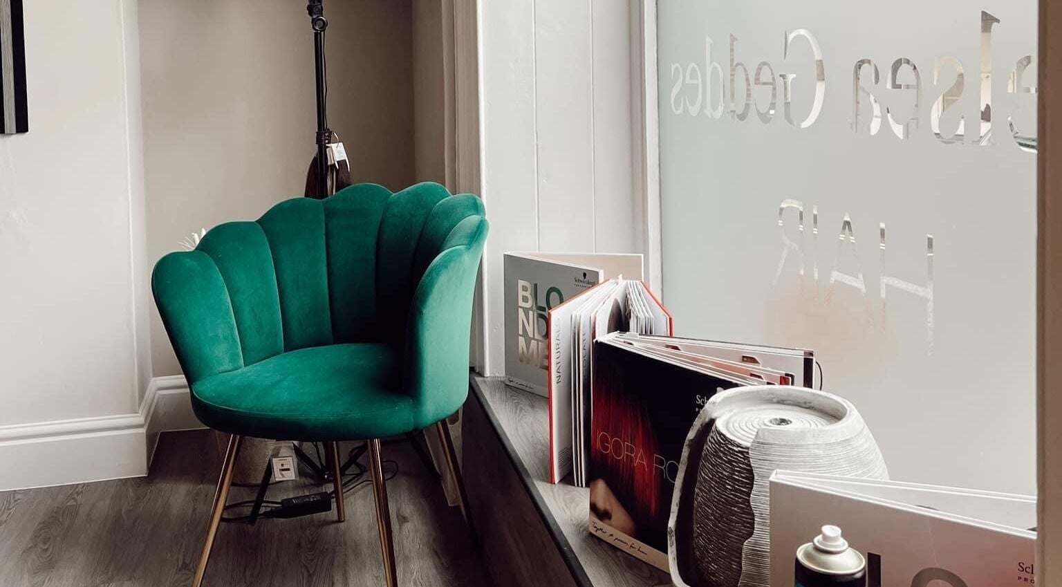 Emerald chair by the window at Chelsea Geddes Hair in Peel, IM, offering a stylish waiting area.