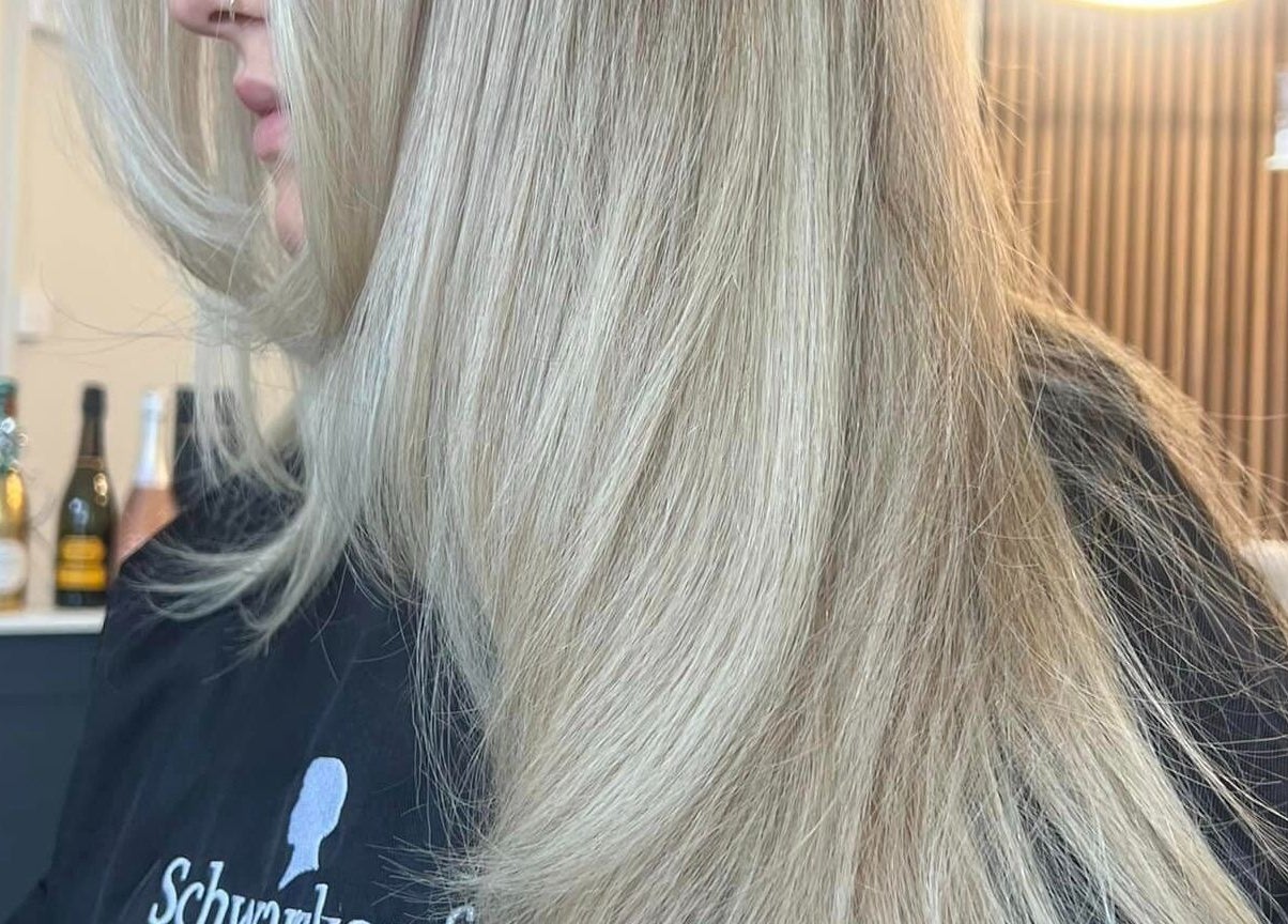 Elegant blonde hairstyle at Chelsea Geddes Hair, Peel, Peel, IM with smooth, flowing strands.