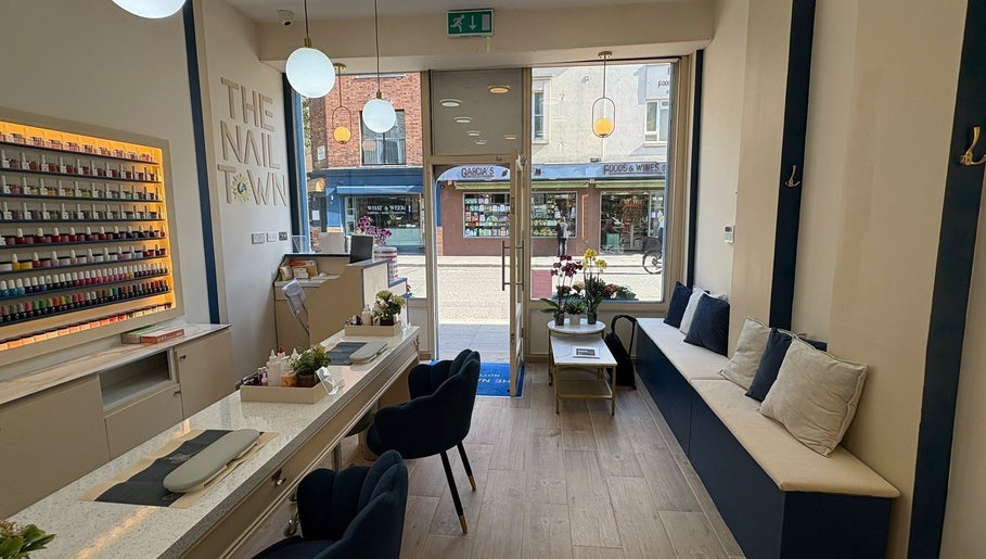 Elegant interior of The Nail Town in London, England, GB with plush seating and vibrant nail polish display.