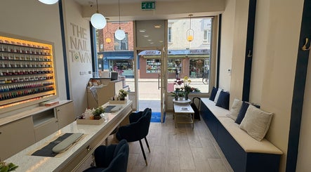 Elegant interior of The Nail Town in London, England, GB with plush seating and vibrant nail polish display.