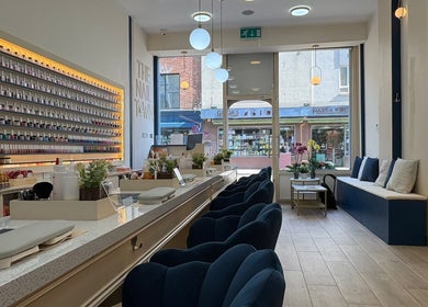 Elegant interior of The Nail Town in London, England, GB featuring plush seating and extensive nail polish selection.