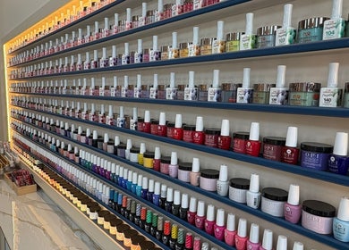 Vibrant nail polish display at The Nail Town, London, England, GB featuring diverse colors on shelves.