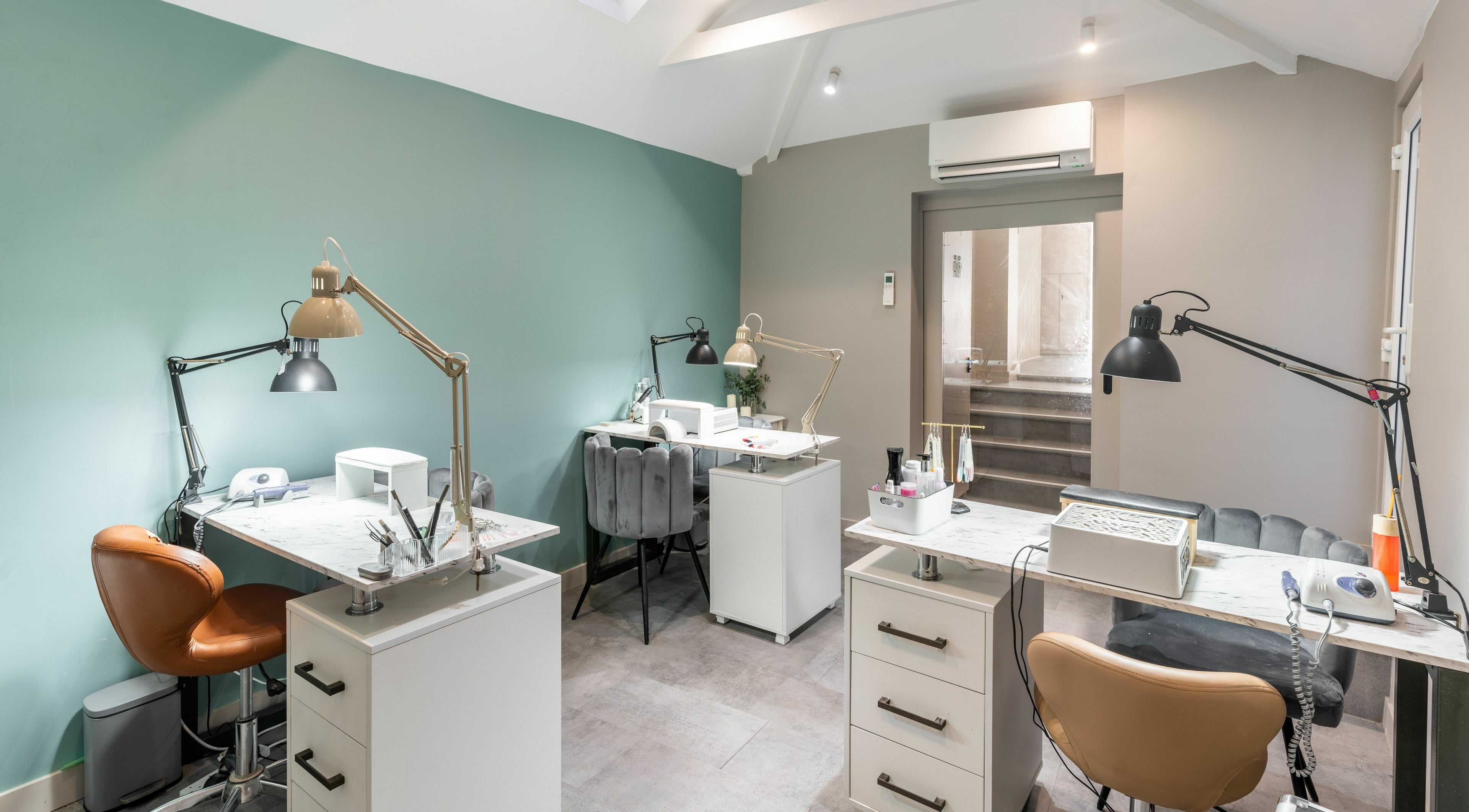 Sleek nail stations at One Beauty Salon, London, England, GB. Modern design with comfortable seating.